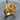 Modern abstract merger ring crafted from sterling silver with gold finish resting on a textured wooden surface