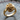 Close-up detailed view of handcrafted gold abstract rose ring resting beautifully on a textured wooden stump surface