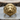 Close-up of gold vermeil roaring lion ring displaying intricate 3D craftsmanship resting on a wooden slice