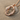 Bird Letter O Pendant, rose gold, on sand and shell
