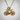Road bicycle pendant, gold vermeil, front view on textured wall