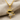 Dancing Doll Pendant, gold vermeil, front view on fabric