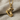 Hockey skate pendant in gold vermeil, angled close-up on fabric