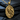 Close-up of handcrafted rock climber pendant resting on dark slate displaying intricate gold vermeil figure details