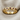 Close-up of 925 sterling silver twisted eternity ring with gold finish and rubies resting on textured fabric