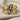 Close-up of 14k gold vermeil embracing wings ring highlighting intricate feather metalwork on linen.