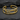 Detailed close-up of the two-tone Ichthys fish earring resting on a textured dark slate background highlighting the finish.