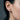 Side profile of model wearing silver crescent moon earring with stars and whispering face design