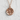 Sakura blossom medallion pendant, rose gold plated, front view on white textured surface