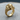 Side angle of the handcrafted majestic elephant ring revealing detailed trunk and ancient motifs on wooden base
