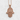 Lotus Eye Hamsa Hand Pendant in rose gold, front view against textured wall