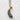 Front view of two-tone kawaii shrimp tempura jewelry piece resting flat on a textured white stone surface