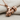 Grip Barbell Pendant, rose gold, angled view on fabric