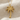 Palm tree pendant, gold vermeil, front view on fabric