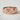 Detailed view of floral band ring with embossed flower motif resting on marble textured background