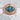 Turquoise dragon eye ring, rose gold, front view on stone pedestal