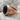 First Division Onyx Signet Ring, rose gold, angled side view on rock