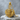Winged Sword Shield Pendant, gold vermeil, resting on stone
