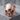 Angry Skull Ring, rose gold, front view on stone pedestal