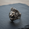 Front view of handcrafted 925 sterling silver crowned lion ring with detailed mane on dark stone background