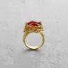 Gold vermeil Silver Three Graces Ring featuring sculpted female figures holding a red gemstone on texture
