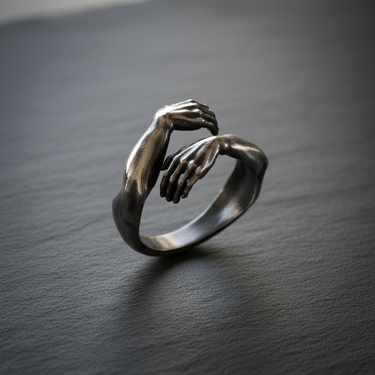 Side view of oxidized silver hug ring showing detailed fingers and muscle texture with vintage finish