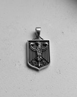 Top view of 925 silver Bundesadler pendant highlighting intricate eagle feathers and shield shape on grey background