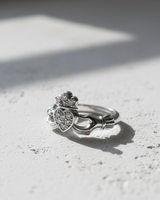 Angled close-up of antique finish sterling silver Claddagh ring with cubic zirconia accents