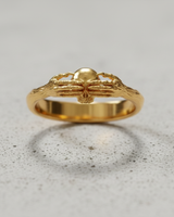 Gold vermeil death claddagh ring featuring skeletal hands holding a skull on neutral background