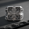 Front view of silver square cross ring featuring raised cross and black oxidized filigree background on stone surface