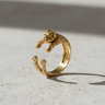 Gold vermeil bulldog ring featuring adjustable hugging paws design on light background