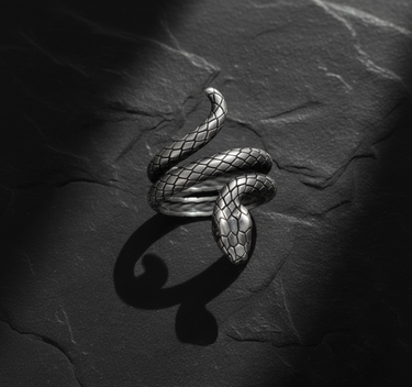 Side profile of handcrafted silver snake ring displaying realistic head detail and oxidized finish with shadow