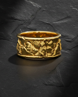 Gold vermeil howling wolf ring featuring mountain landscape and pine trees on dark stone background