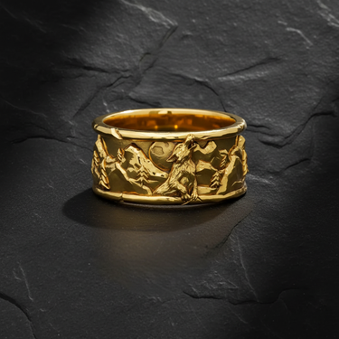 Gold vermeil howling wolf ring featuring mountain landscape and pine trees on dark stone background