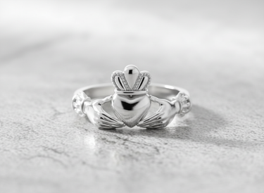 Angled close-up of sterling silver Celtic Claddagh ring showing intricate crown and heart details