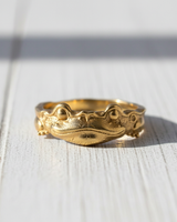 Front view of 14K gold vermeil silver frog ring featuring textured skin and bulging eyes on white wood