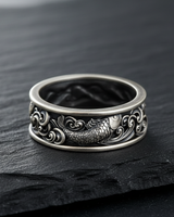 Oxidized 925 sterling silver koi wave ring with detailed fish scales on textured black slate