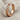 Diagonal Twist Ring, rose gold, angled standing view on fabric