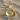 Close-up of the handcrafted serpent gemstone ring resting in the sand, highlighting the detailed snake head and bright gem