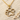 Beautiful gold paw print pendant necklace resting on textured beach sand surrounded by tiny decorative seashells