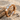 Three stone engagement ring, rose gold, product photo on sand