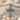 Close-up of silver cross pendant showing oxidized finish and pave set stones on textured surface