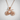 Road bicycle pendant, rose plated silver, front view on textured wall