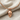 Anatomical Skull Pendant, rose gold, front view on linen with chain