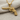 Checkered Grip Revolver Pendant, gold vermeil, front view on fabric