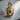 Close-up of premium organic jewelry acorn pendant resting naturally on a textured circular wooden log slice background