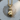 Detailed 925 sterling silver boxing glove pendant with gold finish resting on a textured wooden surface