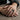 Lifestyle shot of oxidized silver Atlas globe ring worn on a man's hand resting on a rustic wooden table setting