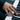 Hand modeling the oxidized silver winged equality ring while playing a classic black and white piano keyboard.