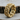 Close-up of the luxurious gold vermeil miami cuban link ring with oxidized floral pattern resting on a wooden log